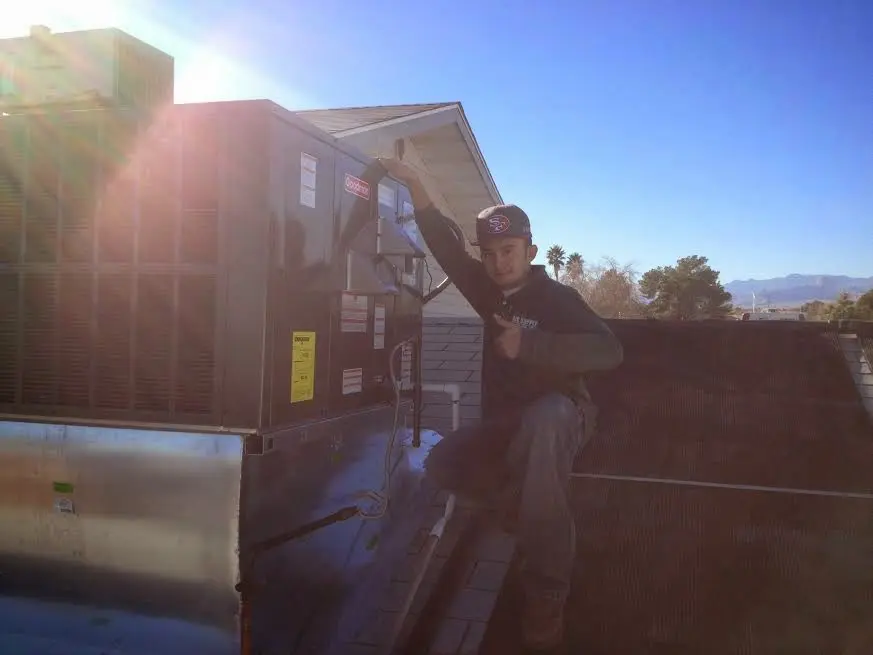 HVAC technician performing Heat Pump Repair on a rooftop unit in Lower Allen
